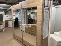 click to see larger image of This stunning 226cm wide x 210cm high sliding door wardrobe comes with 1 shelf and 1 rail in each of the extra wide compartments. Shown in stock for prompt delivery in Sonoma Oak colour. Available to order in other colours. FREE DELIVERY AND ASSEMBLY IN OUR AREA BY TRAINED STAFF. FAMILY SERVICE FROM A LOCAL BUSINESS.